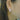 Close-up of an ear wearing a diamond earring with blurred background