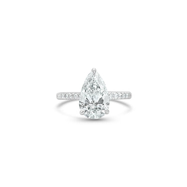 Diamond ring with a pear-shaped center stone on a white background