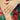Close-up of a hand wearing an engagement ring with a colorful floral background
