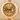 Gold Rolex watch with diamond-studded face on a beige background