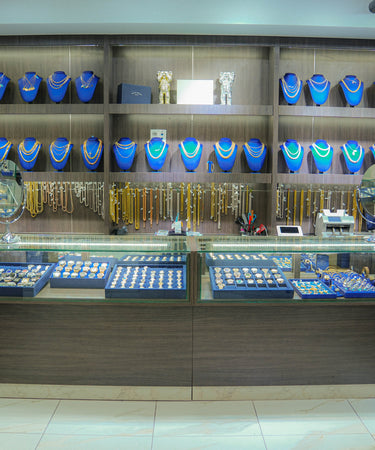 Jewelry store display with various necklaces and jewelry on shelves.