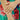 Close-up of a hand wearing a ring with a colorful floral background