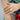 Close-up of a hand wearing a diamond ring with a colorful floral background