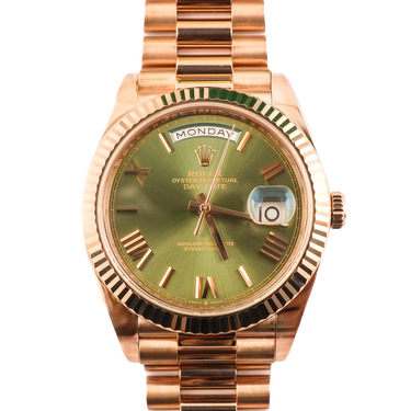 Luxury watch with rose gold case and green dial on a white background