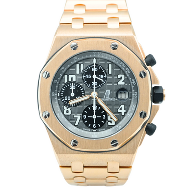 Gold watch with a dark gray face on a white background