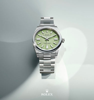 Silver watch with a light green face on a gray background