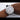 Luxury watch with diamond-studded bezel and black strap on a wrist