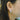 Close-up of an ear wearing a diamond hoop earring with blurred background