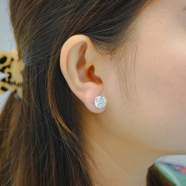 Close-up of an ear wearing a diamond earring with blurred background