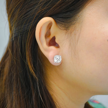 Close-up of an ear wearing a diamond earring with blurred background