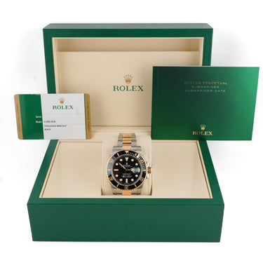 Rolex watch in a green Rolex box with the Rolex warranty papers on a white background