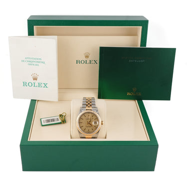 Rolex watch in a green Rolex box with warranty papers on a white background