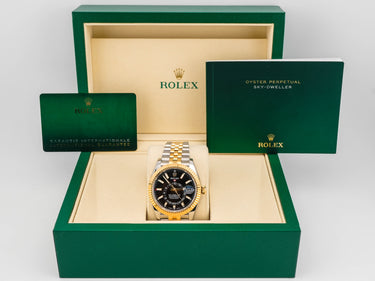 Rolex watch in a green box with accessories on a white background