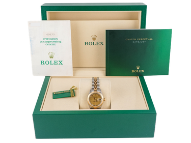 Rolex watch in an open green box with accessories on a white background