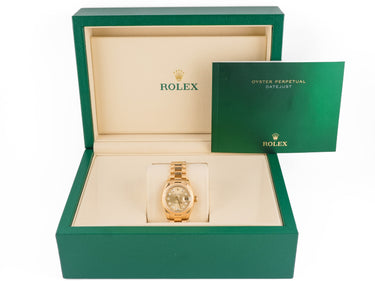 Gold watch in a green Rolex box on a white background