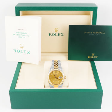 Gold Rolex watch in a green and beige box with the brand logo visible.