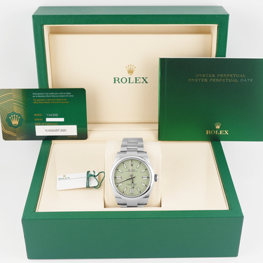 Rolex watch in a green box with a card and certificate on a white background