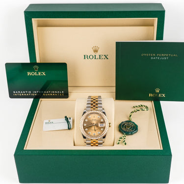 Rolex watch in a green box with accessories on a white background