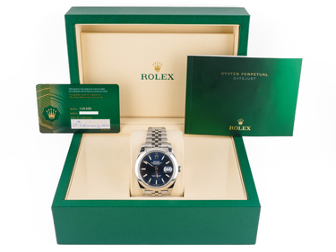 Rolex watch in a green box with accessories on a white background
