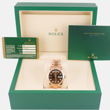 Rolex watch in a green box with a certificate of authenticity on a white background
