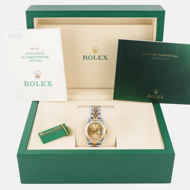 Rolex watch in a green box with accessories on a white background