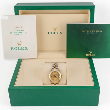 Rolex watch in a green box with branded materials on a white background