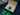 Rolex watch in an open green and beige box on a dark surface