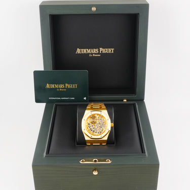 Gold watch in a green Audemars Piguet box on a white background