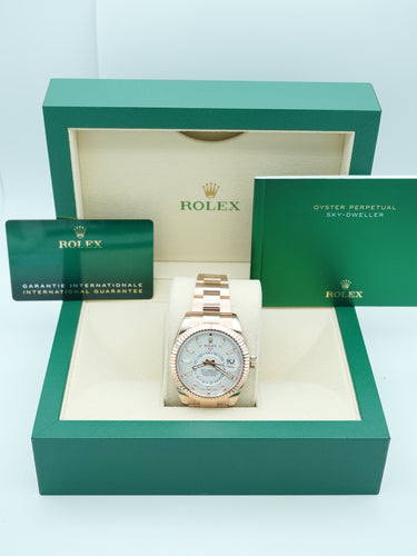 Rose gold Rolex watch with a white face on a Rolex box