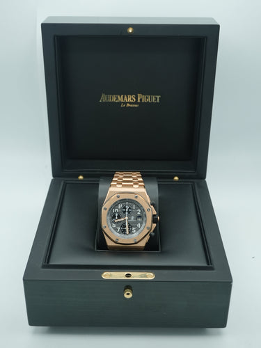Gold watch with a dark gray face on a black box