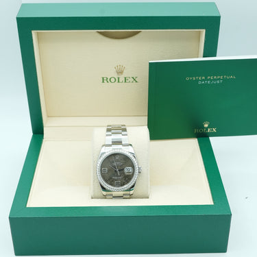 silver Rolex watch with a floral face on a green Rolex box 
