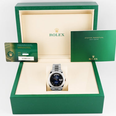 Rolex watch in an open green box with the brand logo visible.