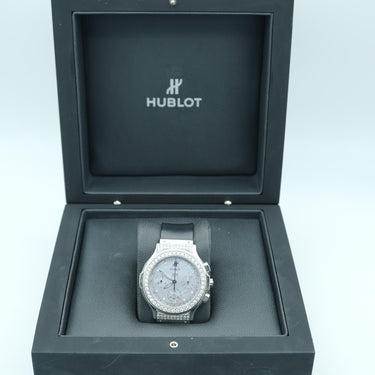 Hublot watch in a black display box on a light blue background