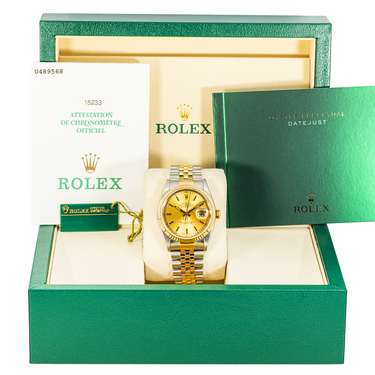 Gold Rolex watch in a green box with accessories