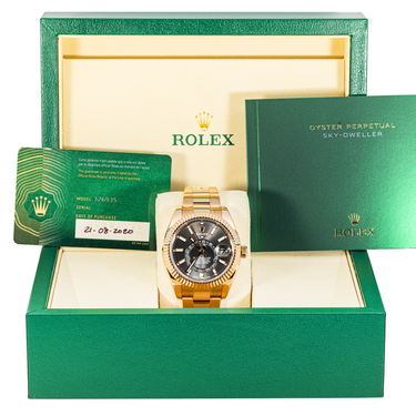 Gold Rolex watch in a green box with the brand logo visible