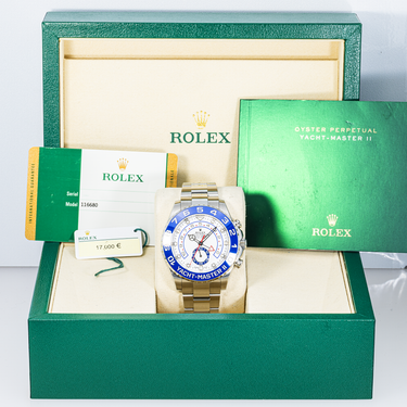 Rolex watch in a green Rolex box and warranty card on a white background