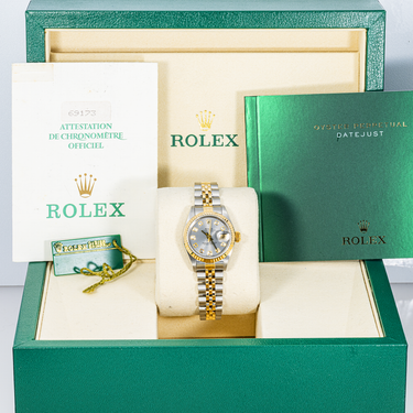 Rolex watch in a green Rolex box with warranty papers