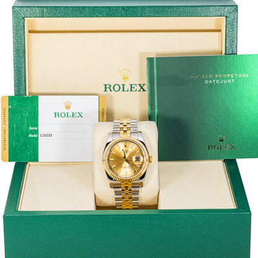Gold watch in a green Rolex box with accessories