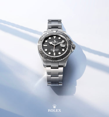 Silver Rolex watch on a light blue background