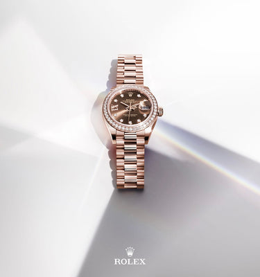 Rose gold watch with diamond accents on a white background, featuring the Rolex logo.