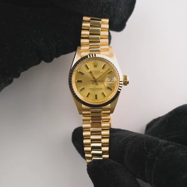 Gold Rolex watch on a white background