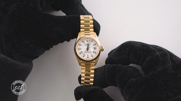 Gold watch with a white face on a white background