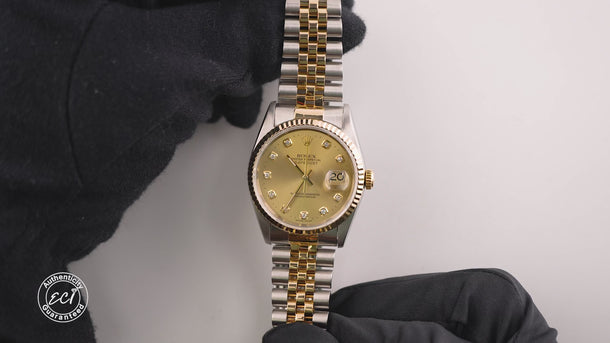 Two-tone gold and silver watch with a gold face on a white background