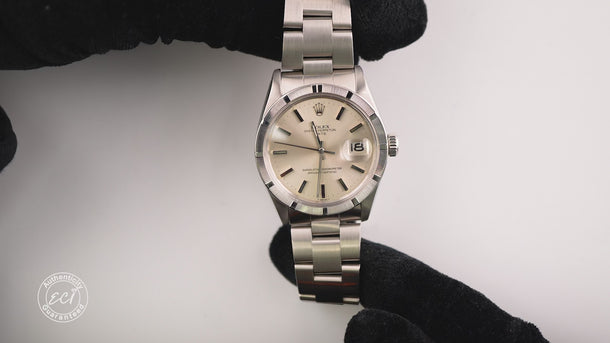 Silver wristwatch with a white face on a white background
