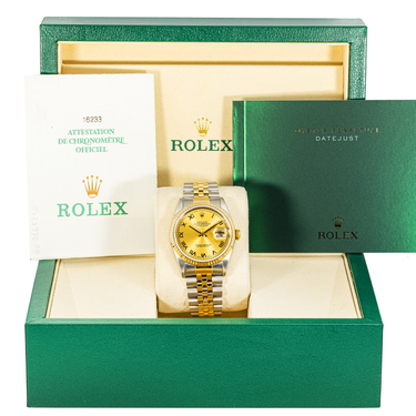 Gold and silver Rolex watch in a green box with a white interior